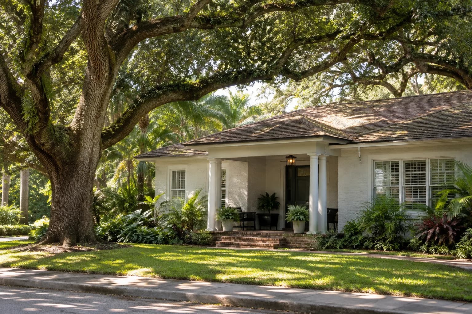 An older South Miami home under large oak trees